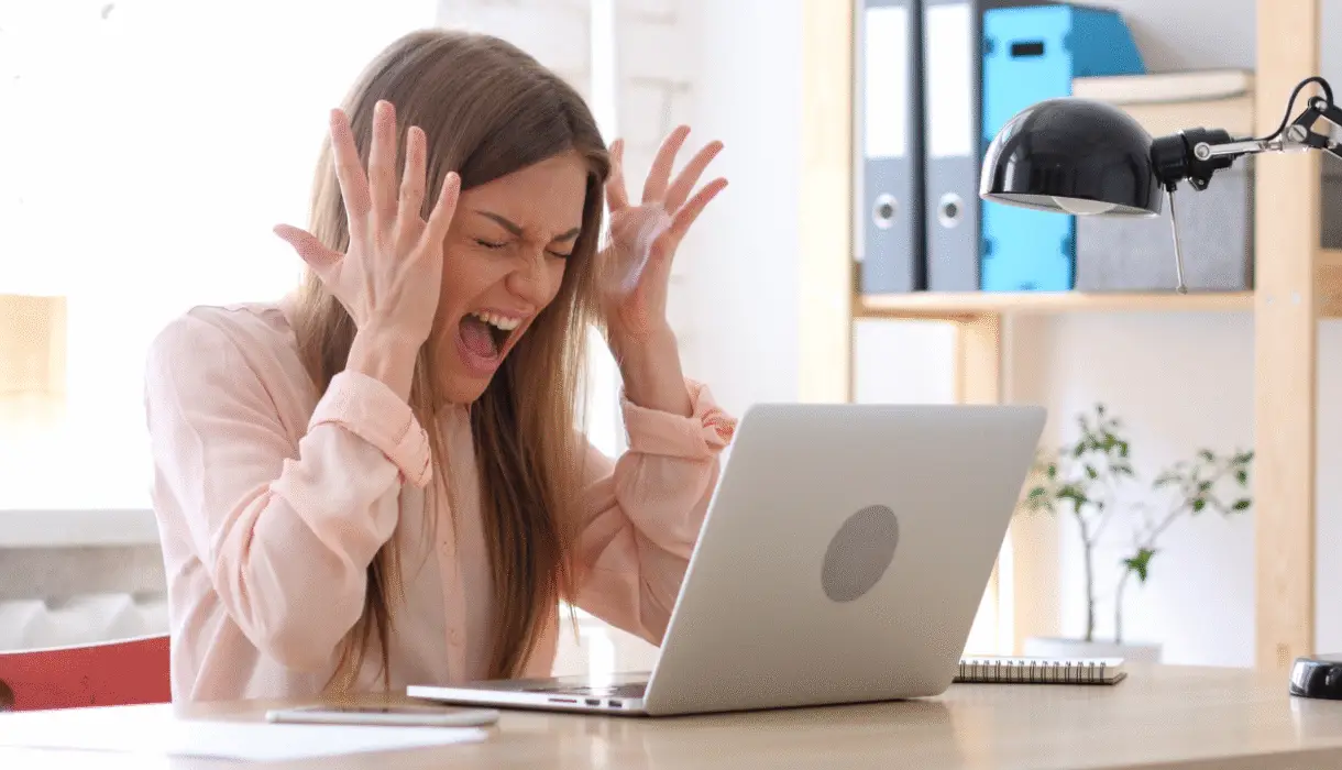 Business owner in front of her computer feeling frusterated.